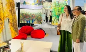Nghệ sĩ Trần Mạnh Tuấn xem tranh của Xèo Chu